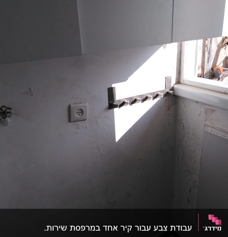 קיר עם סדקים וכתמי צבע, שקע חשמל